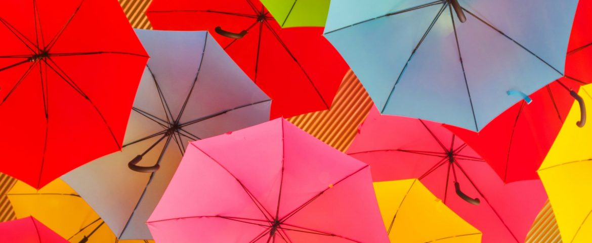 Colorful umbrellas hanging from a roof, creating an interesting abstract background.